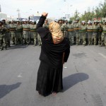 Uyghur woman facing a police cordon during protests in Xinjiang in 2009. Photo: REUTERS